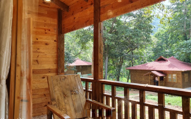 Wooden balcony chairs overlooking the resort grounds